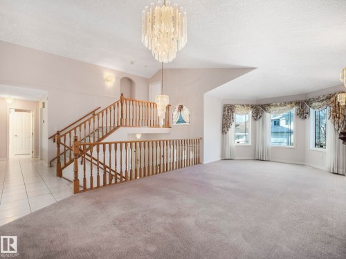 Spacious living area featuring light gray carpeting and a bay window with decorative valances - 1054 Ormsby Crescent, Edmonton, AB - Indoor Photo Showing Other Room