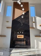 Two-story accent wall featuring black veined tile and wood-finish paneling - 