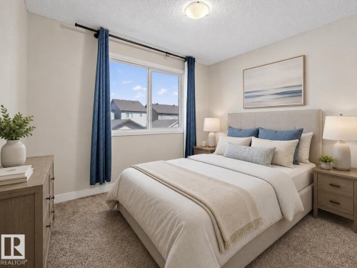 Bedroom featuring a large window, neutral wall paint, textured carpeting, and a flush-mount ceiling light - 45 4470 Prowse Road, Edmonton, AB - Indoor Photo Showing Bedroom