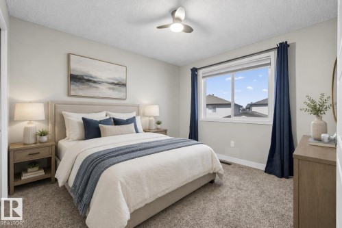 Spacious room featuring neutral paint, soft carpet flooring, a ceiling fan, and a large window - 45 4470 Prowse Road, Edmonton, AB - Indoor Photo Showing Bedroom