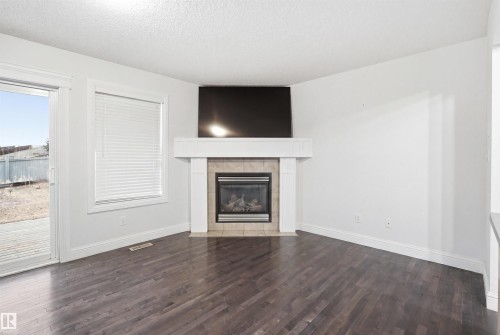 Living area featuring a gas fireplace with a tiled surround and a white mantel - 3545 11 Street, Edmonton, AB - Indoor Photo Showing Living Room With Fireplace