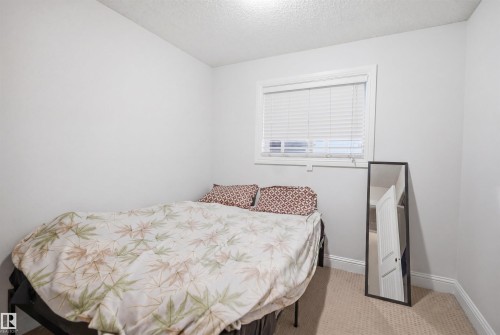 Carpeted room with light gray walls, white baseboards, and a single window featuring white blinds and trim - 3545 11 Street, Edmonton, AB - Indoor Photo Showing Bedroom