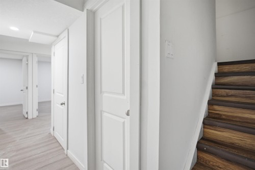 Hardwood stairs with dark risers, light gray walls, and wood-finish flooring - 3545 11 Street, Edmonton, AB - Indoor Photo Showing Other Room