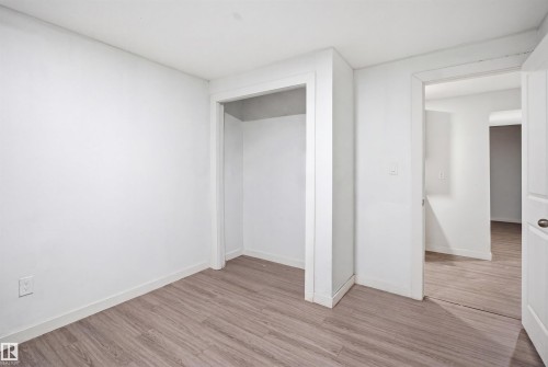 Interior room featuring light wood-finish flooring, white walls, and a built-in closet with white trim - 3545 11 Street, Edmonton, AB - Indoor Photo Showing Other Room