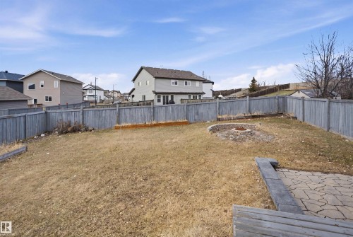 Fenced backyard featuring a paver patio area, fire pit, and sloped landscaping - 3545 11 Street, Edmonton, AB - Outdoor With Backyard