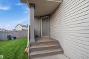 Rear exterior with light-colored horizontal siding, a covered entry, and a side-hinged door - 3545 11 Street, Edmonton, AB  - Outdoor With Exterior 
