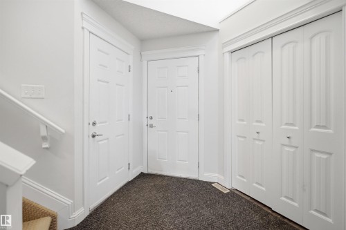 Entry foyer featuring a paneled door, bi-fold closet doors, wall-mounted light switches, and a carpeted floor - 3545 11 Street, Edmonton, AB - Indoor Photo Showing Other Room