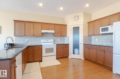 Kitchen featuring wood-finish flooring, recessed lighting, and ample cabinetry - 7426 Getty Way, Edmonton, AB - Indoor Photo Showing Kitchen