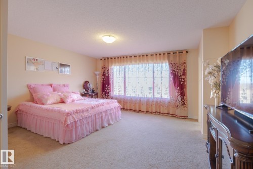Spacious room with large windows, wall-to-wall carpeting, a built-in overhead light fixture, and light-colored walls - 7426 Getty Way, Edmonton, AB - Indoor Photo Showing Bedroom