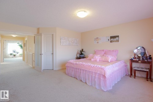 Carpeted room with a hallway entry, featuring a tray ceiling and recessed lighting - 7426 Getty Way, Edmonton, AB - Indoor Photo Showing Bedroom