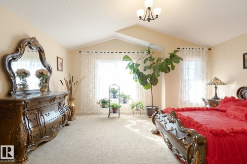 Spacious room featuring vaulted ceilings, light carpeting, and dual windows with sheer curtains - 7426 Getty Way, Edmonton, AB - Indoor Photo Showing Bedroom