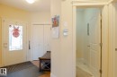 Entryway featuring a white door with decorative glass inserts, bi-fold closet doors, and wood-finish flooring - 7426 Getty Way, Edmonton, AB  - Indoor Photo Showing Other Room 