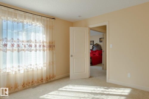 Carpeted room with a large window featuring horizontal blinds - 7426 Getty Way, Edmonton, AB - Indoor Photo Showing Other Room