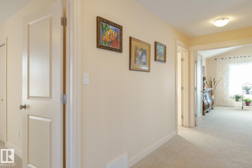 Hallway with light beige carpeting and matching wall paint - 7426 Getty Way, Edmonton, AB - Indoor Photo Showing Other Room