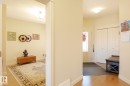 Entryway featuring hardwood flooring, a white paneled entry door with decorative glass inserts, and a built-in double-door closet with louvered doors - 7426 Getty Way, Edmonton, AB  - Indoor Photo Showing Other Room 