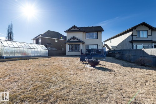 Expansive backyard featuring a large greenhouse structure, a ground-level deck, and a fire pit - 7426 Getty Way, Edmonton, AB - Outdoor