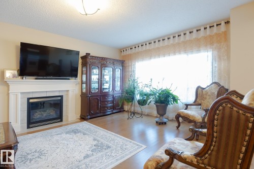 Bright living area featuring a fireplace with a white mantel and tile surround - 7426 Getty Way, Edmonton, AB - Indoor Photo Showing Living Room With Fireplace