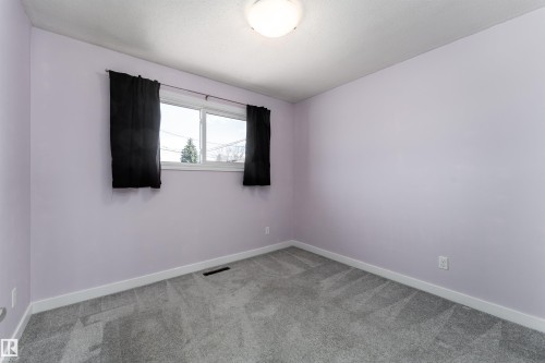 Carpeted interior room featuring light lavender walls, a double-paned window, and a flush mount ceiling light - 13331 64 Street Nw, Edmonton, AB - Indoor Photo Showing Other Room
