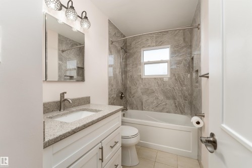 Bathroom featuring a white vanity with a light-toned countertop and an undermount sink - 13331 64 Street Nw, Edmonton, AB - Indoor Photo Showing Bathroom