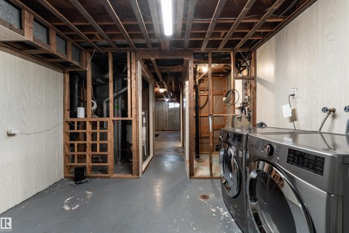 Lower level featuring exposed ceiling joists and partial wood paneling - 13331 64 Street Nw, Edmonton, AB - Indoor Photo Showing Laundry Room