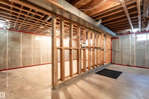 Unfinished basement featuring exposed wood ceiling joists and support beams, concrete flooring, and framed interior walls - 13331 64 Street Nw, Edmonton, AB - Indoor Photo Showing Basement