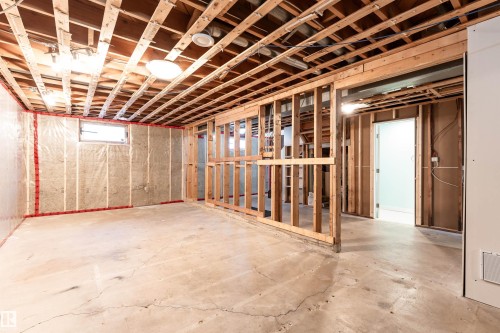 Unfinished interior space featuring exposed wood framing, concrete flooring, and ceiling joists - 13331 64 Street Nw, Edmonton, AB - Indoor Photo Showing Basement