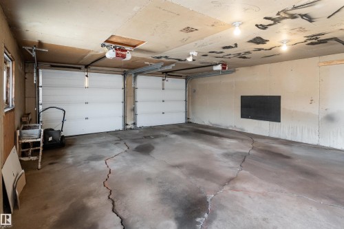 Two garage doors with automatic openers - 13331 64 Street Nw, Edmonton, AB - Indoor Photo Showing Garage