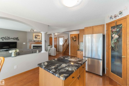 Kitchen island with a dark granite countertop and light wood-finish cabinetry - 17224 83 Street, Edmonton, AB - Indoor Photo Showing Kitchen