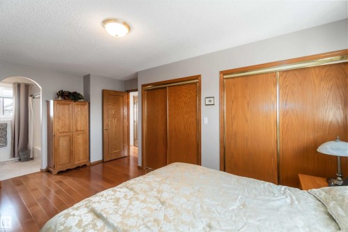 Wood-finish flooring throughout, featuring a cased opening to a separate bathing area - 17224 83 Street, Edmonton, AB - Indoor Photo Showing Bedroom