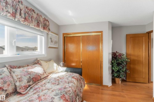 Spacious room featuring a large window, wood-finish flooring, and light gray walls - 17224 83 Street, Edmonton, AB - Indoor Photo Showing Bedroom