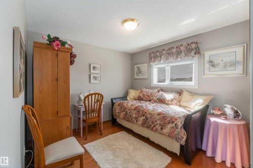 Bright room featuring a window with a valance, light-toned walls, wood-finish flooring, and a ceiling-mounted light fixture - 17224 83 Street, Edmonton, AB - Indoor Photo Showing Bedroom