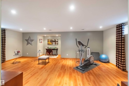 Spacious room featuring wood-finish flooring, recessed lighting, and a neutral wall color - 17224 83 Street, Edmonton, AB - Indoor Photo Showing Gym Room