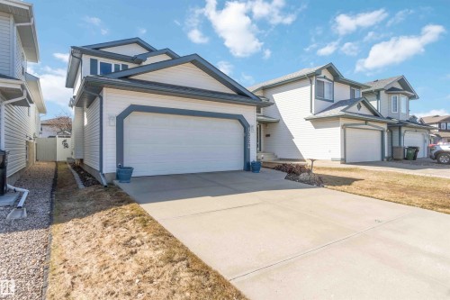 Two-story residence featuring light-colored siding with dark trim accents, an attached two-car garage, and a concrete driveway - 17224 83 Street, Edmonton, AB - Outdoor