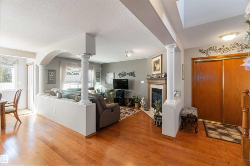 Warm wood-finish flooring throughout the main living areas - 17224 83 Street, Edmonton, AB - Indoor Photo Showing Living Room With Fireplace