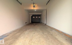 Expansive garage space featuring concrete flooring and painted walls - 