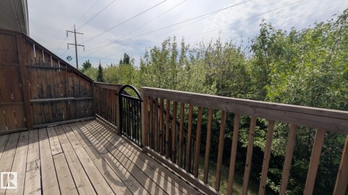 Wood-finish deck featuring a full wood privacy fence and a wrought iron gate - #11 13215 153 Avenue, Edmonton, AB - Outdoor With Deck Patio Veranda