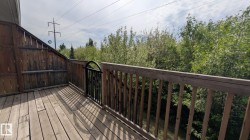 Wood-finish deck featuring a full wood privacy fence and a wrought iron gate - 