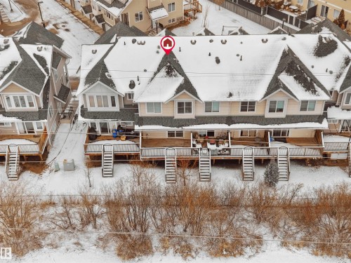 Townhome property featuring individual rear decks with stairs descending to a snow-covered private yard - #11 13215 153 Avenue, Edmonton, AB - Outdoor