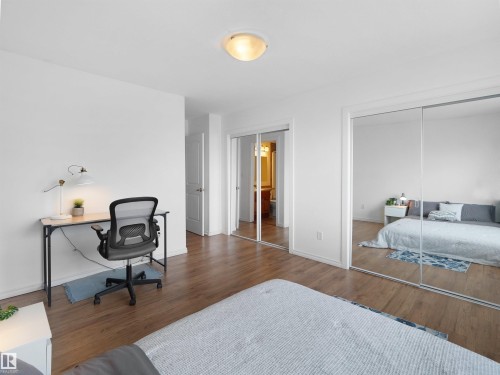 The room features wood flooring, white walls, and a ceiling-mounted light fixture - #11 13215 153 Avenue, Edmonton, AB - Indoor Photo Showing Bedroom