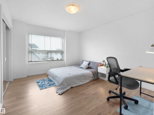 Bedroom featuring light-toned flooring, a window with blinds, and white walls - #11 13215 153 Avenue, Edmonton, AB - Indoor Photo Showing Bedroom