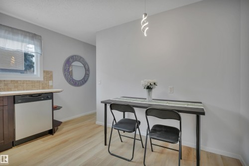 The kitchen features light-toned flooring, a light-colored countertop, and a tiled backsplash - 585 Knottwood Road W, Edmonton, AB - Indoor Photo Showing Other Room