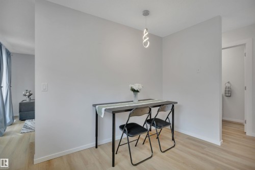 This space features light-toned flooring, a contemporary pendant light fixture, and walls painted in a neutral hue - 585 Knottwood Road W, Edmonton, AB - Indoor