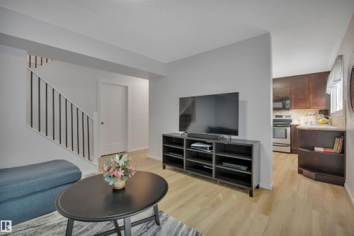 Living area featuring light wood flooring and a staircase with a white railing and black spindles - 585 Knottwood Road W, Edmonton, AB - Indoor Photo Showing Living Room