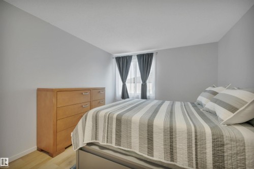The room features light-colored flooring, windows with both sheer and blackout curtains, and a neutral color palette - 585 Knottwood Road W, Edmonton, AB - Indoor Photo Showing Bedroom