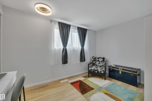 The room features light wood flooring, light grey walls, and a contemporary ceiling light fixture - 585 Knottwood Road W, Edmonton, AB - Indoor Photo Showing Other Room
