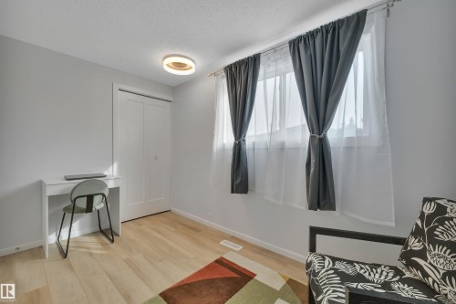 This room features light hardwood flooring, light grey walls, and a modern ceiling light fixture - 585 Knottwood Road W, Edmonton, AB - Indoor