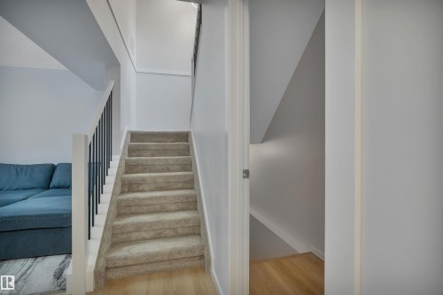 Staircase featuring carpeted steps and a white banister with black spindles - 585 Knottwood Road W, Edmonton, AB - Indoor Photo Showing Other Room