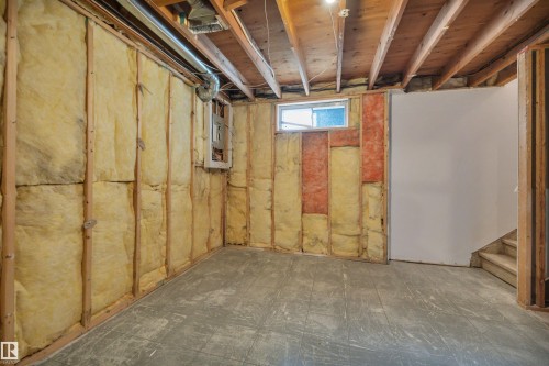 Unfinished basement with exposed wooden joists and partial insulation, featuring a small window and concrete flooring - 585 Knottwood Road W, Edmonton, AB - Indoor Photo Showing Basement