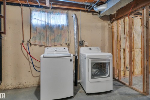 Dedicated laundry area with a top-loading washing machine and front-loading dryer - 585 Knottwood Road W, Edmonton, AB - Indoor Photo Showing Laundry Room