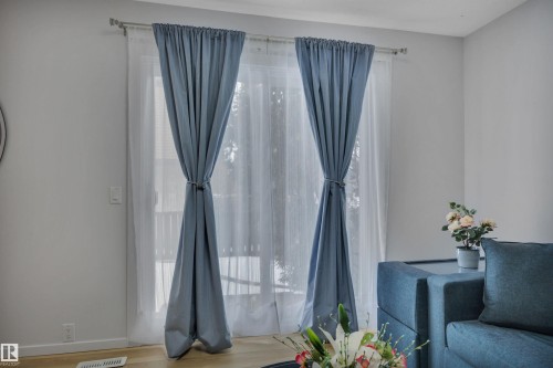 This space features a large window with sheer and blue curtains, allowing for customizable natural light - 585 Knottwood Road W, Edmonton, AB - Indoor